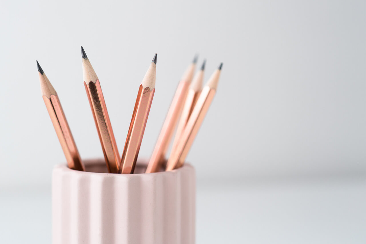 potloden in roze bakje en witte achtergrond