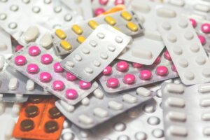 grijze pillenstrips met witte, gele en roze pillen