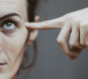 schuldig/ vrouw wijst met vinger tegen haar hoofd