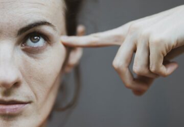 schuldig/ vrouw wijst met vinger tegen haar hoofd